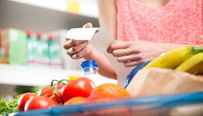 Woman with receipt. Grocery mistakes kill your food budget