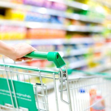 Hands pushing a grocery cart in an aisle