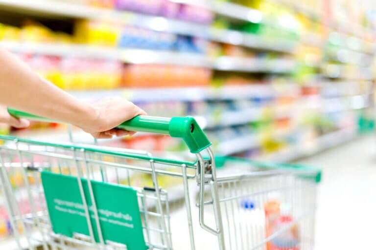 Hands pushing a grocery cart in an aisle